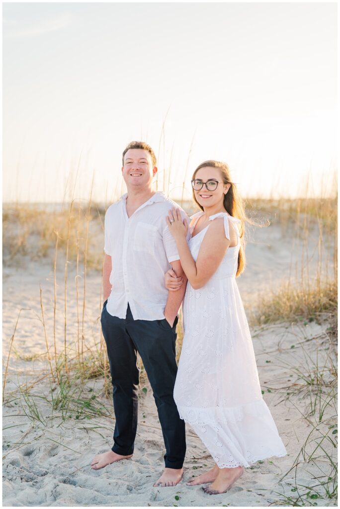 husband and wife standing on the sand at Wrightsville Beach