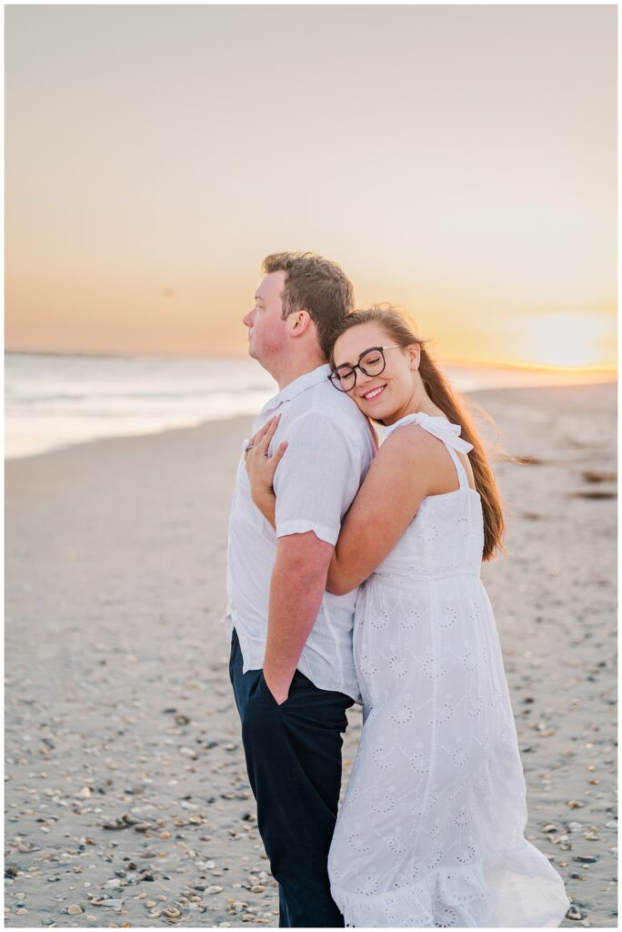 couple standing on the sand at sunset in Wrightsville Beach, NC