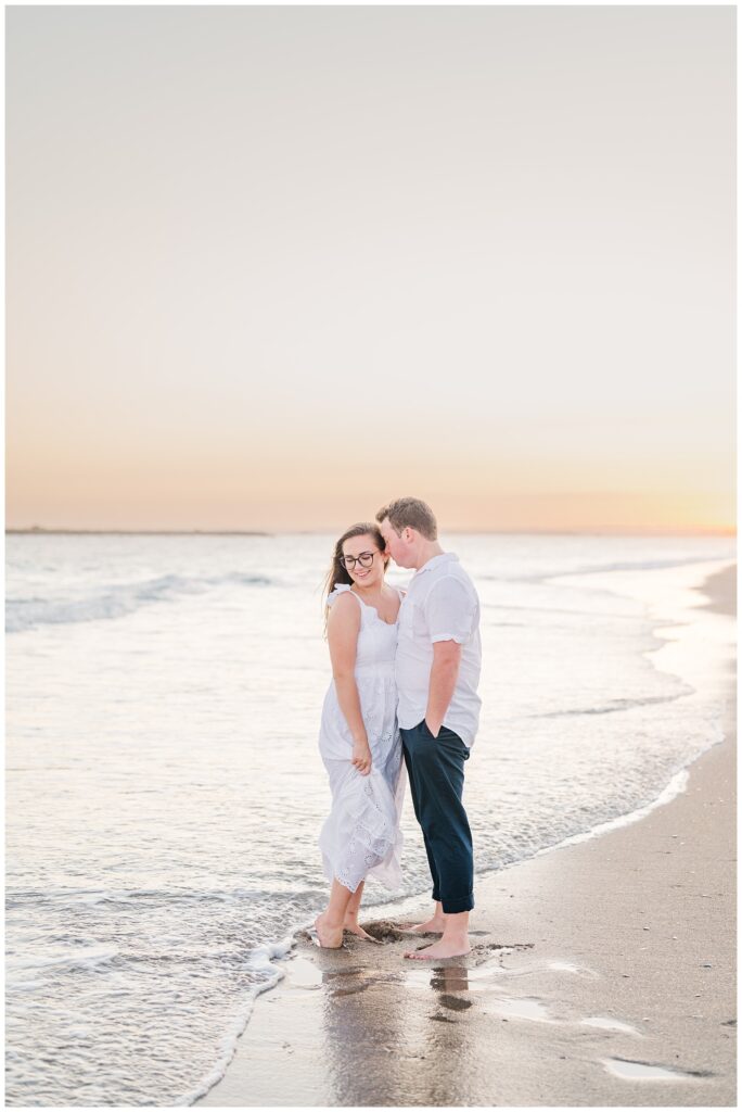 couple standing in the ocean at Wrightsville Beach at sunset