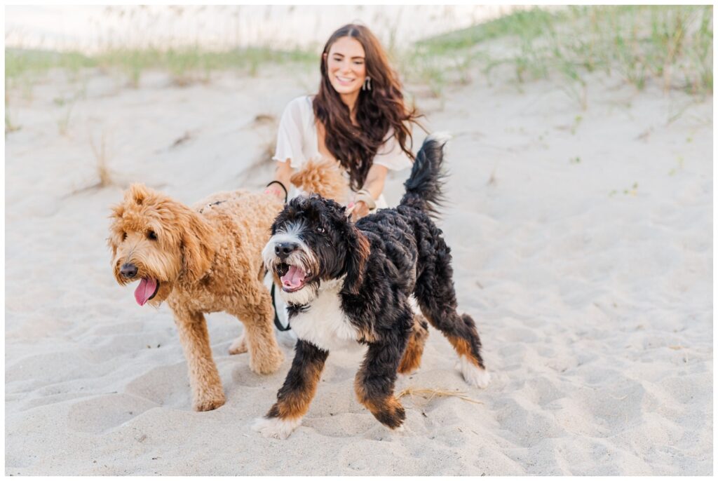 dog owner holding her two dogs on the beach in Wilmington
