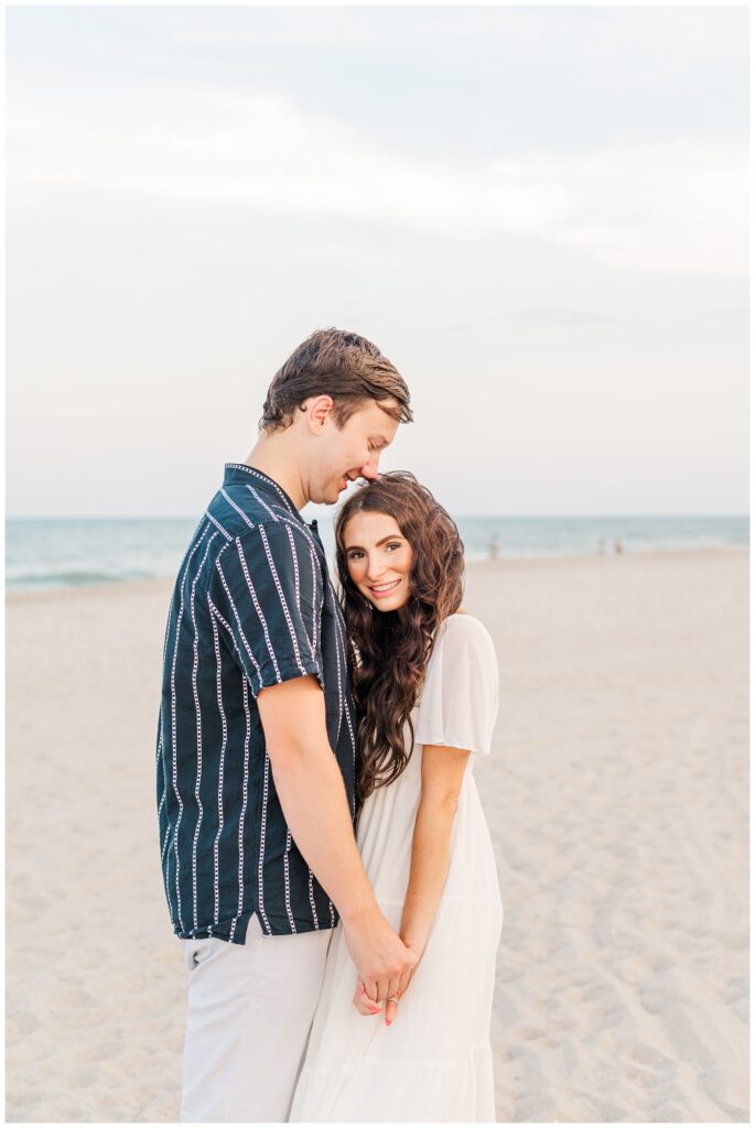 couple holding hands on the beach for Wilmington engagement