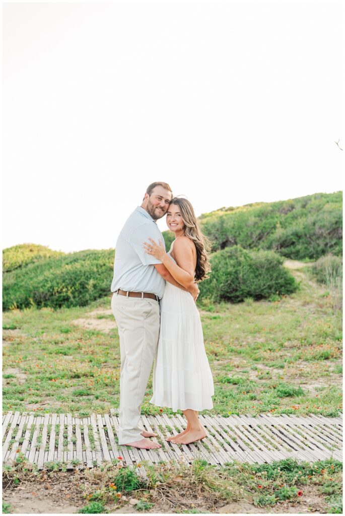 couple posing on a wooden walkway at Fort Fisher engagement session