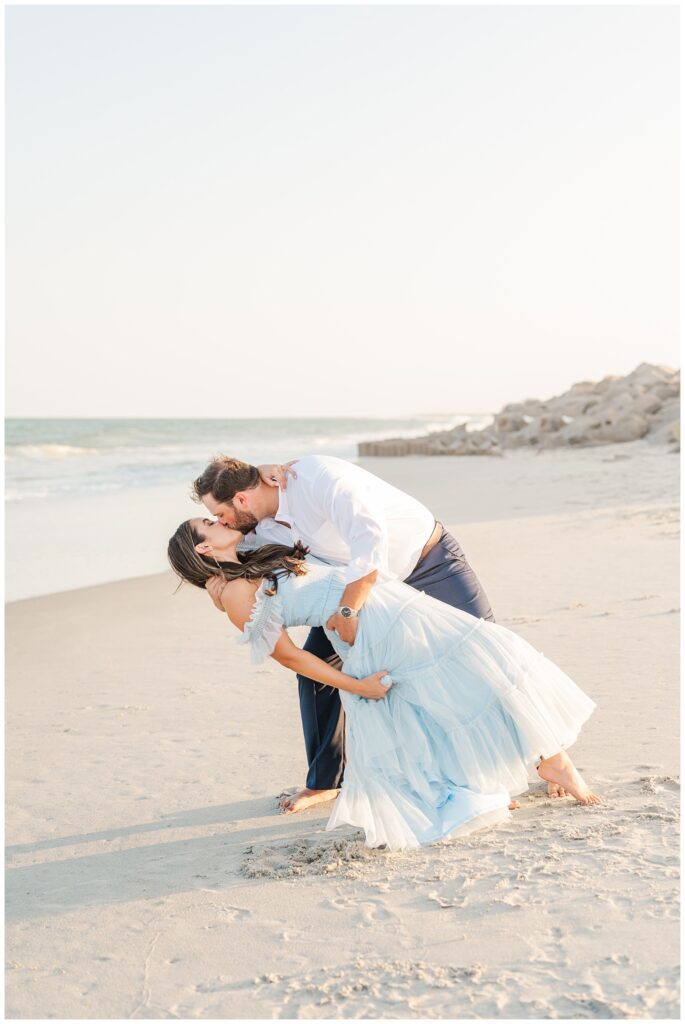man dipping back his fiance at Fort Fisher engagement shoot