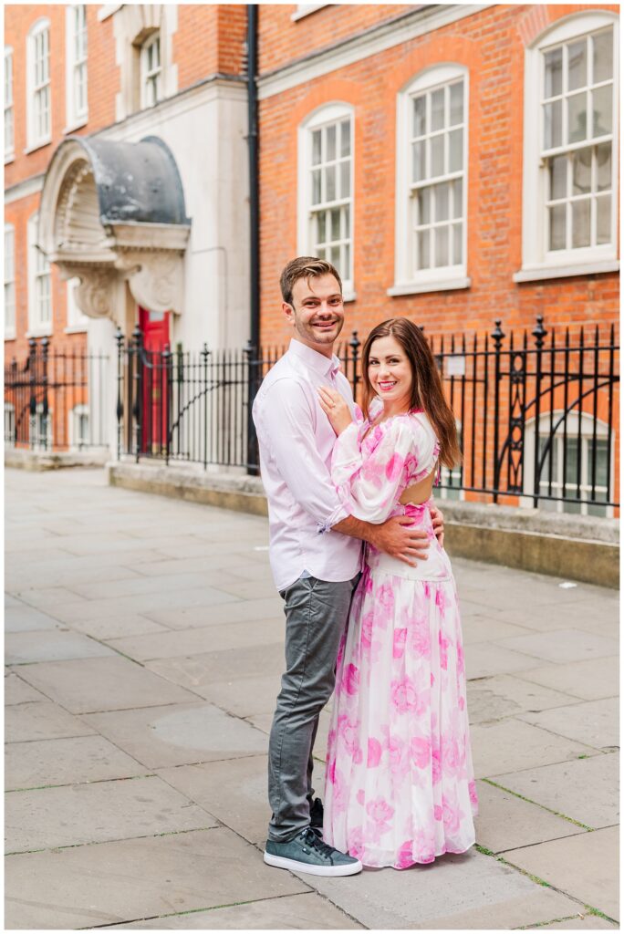 engaged couple standing on a sidewalk in London