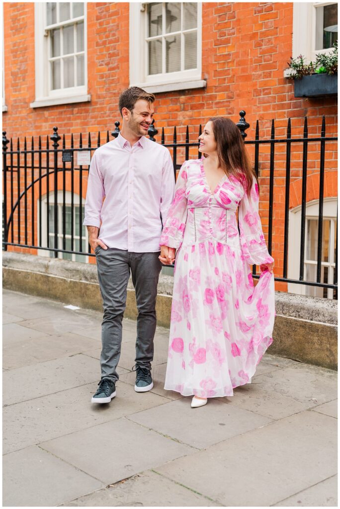 couple holding hands and walking in downtown London  for engagement