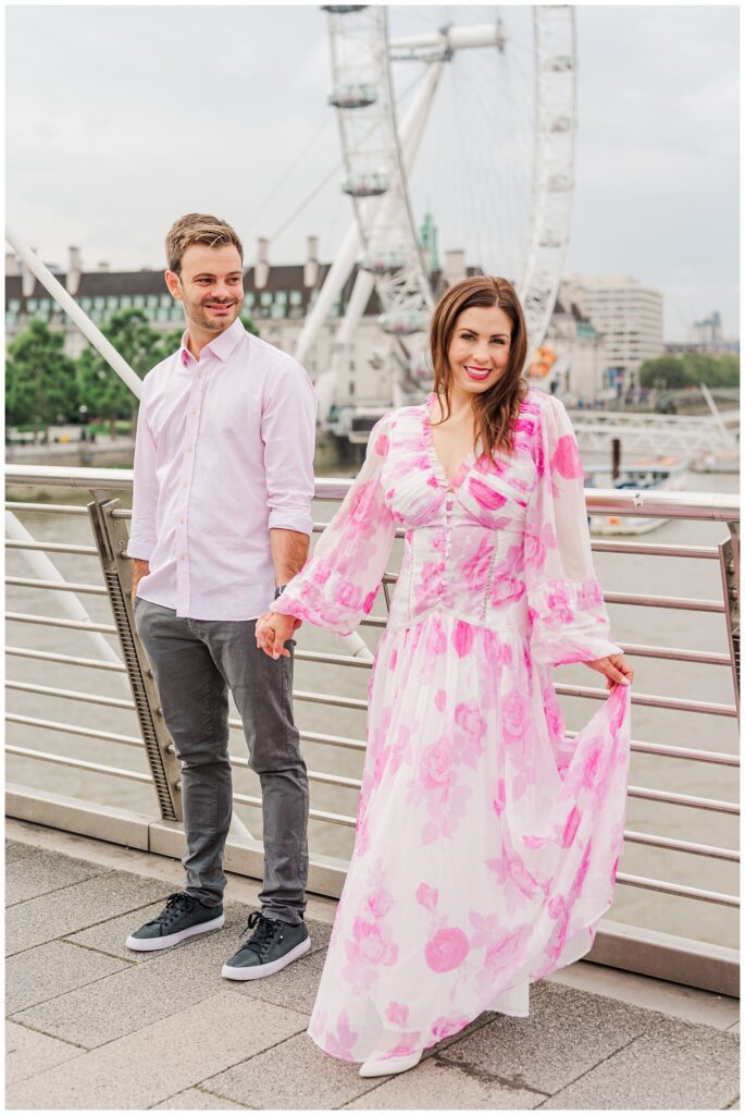 woman holding the side of her pink dress at London engagement session