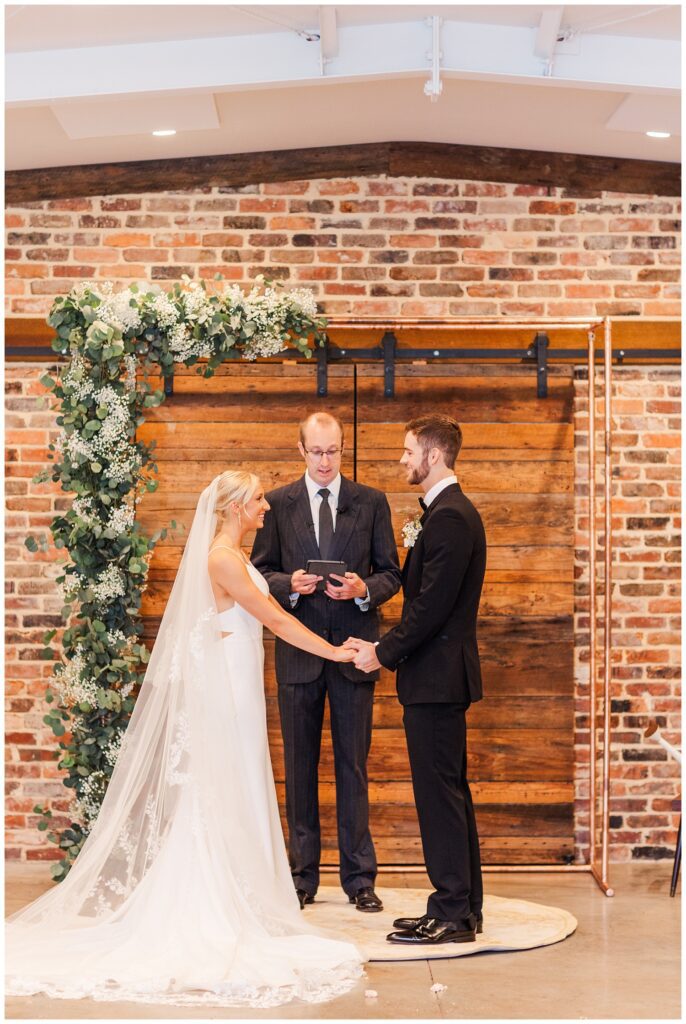 wedding couple holding hands at ceremony in Raleigh, NC