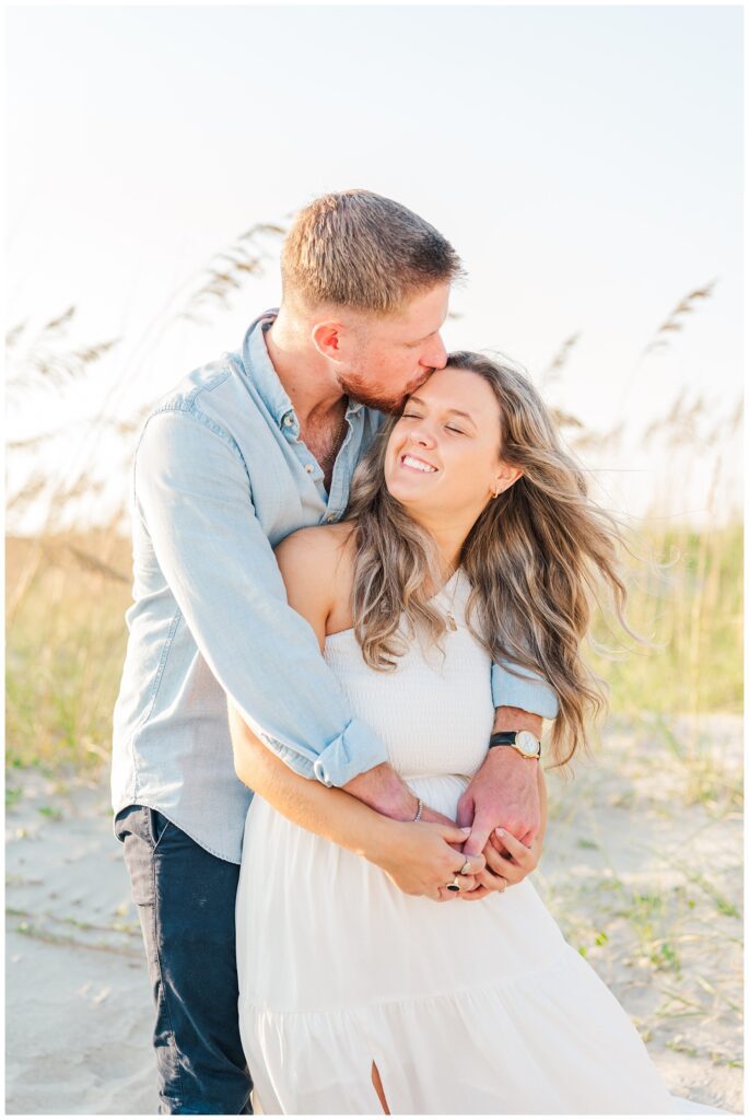 couple posing on the beach for Oak Island, NC engagement session