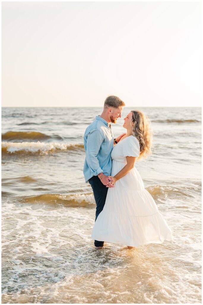 couple dancing in the ocean at Oak Island engagement session