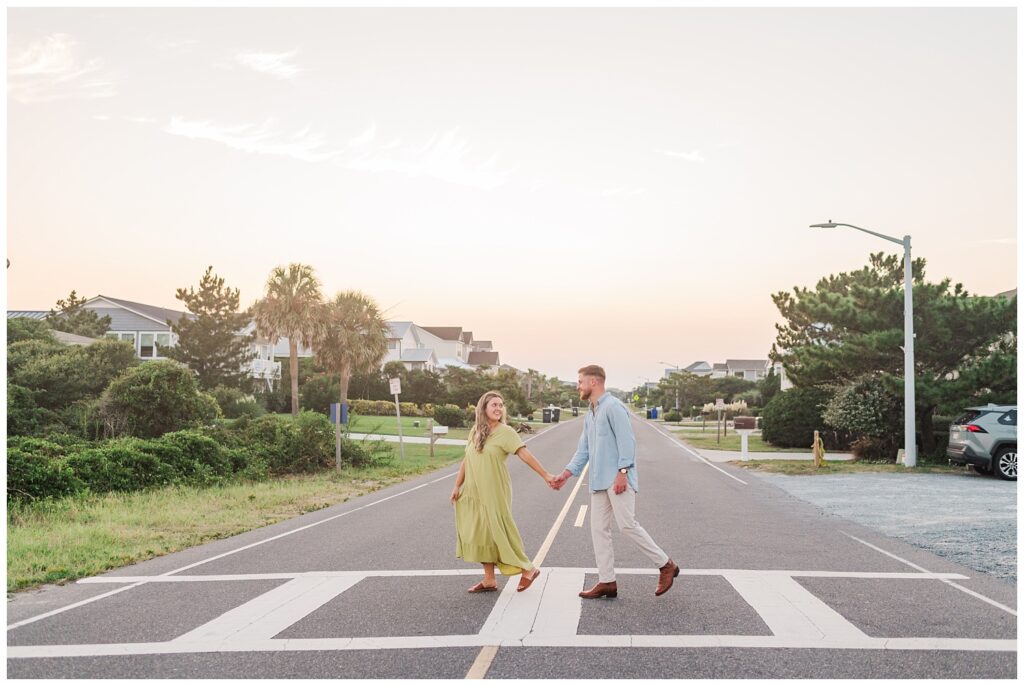 engaged couple crossing the street near the beach in Oak Island, NC