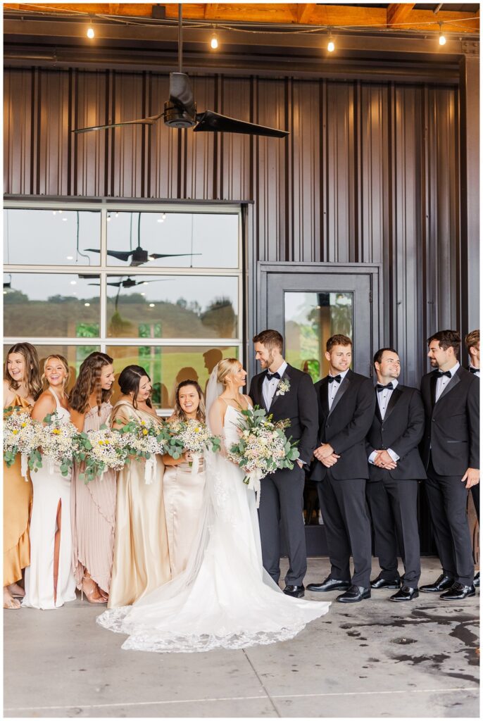 full wedding party posing under cover at Raleigh venue