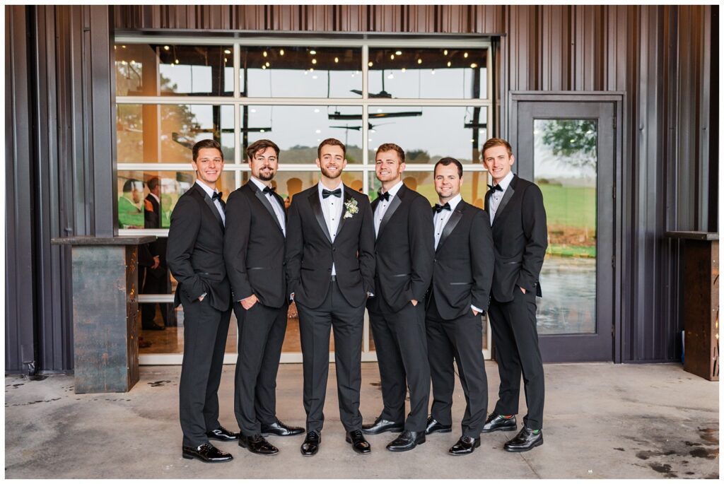groomsmen posing together under cover at The Meadows Raleigh