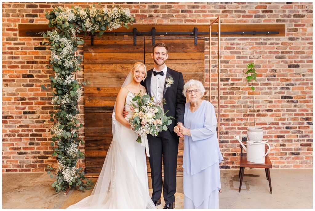 bride and groom posing with grandmother at fall wedding in Raleigh