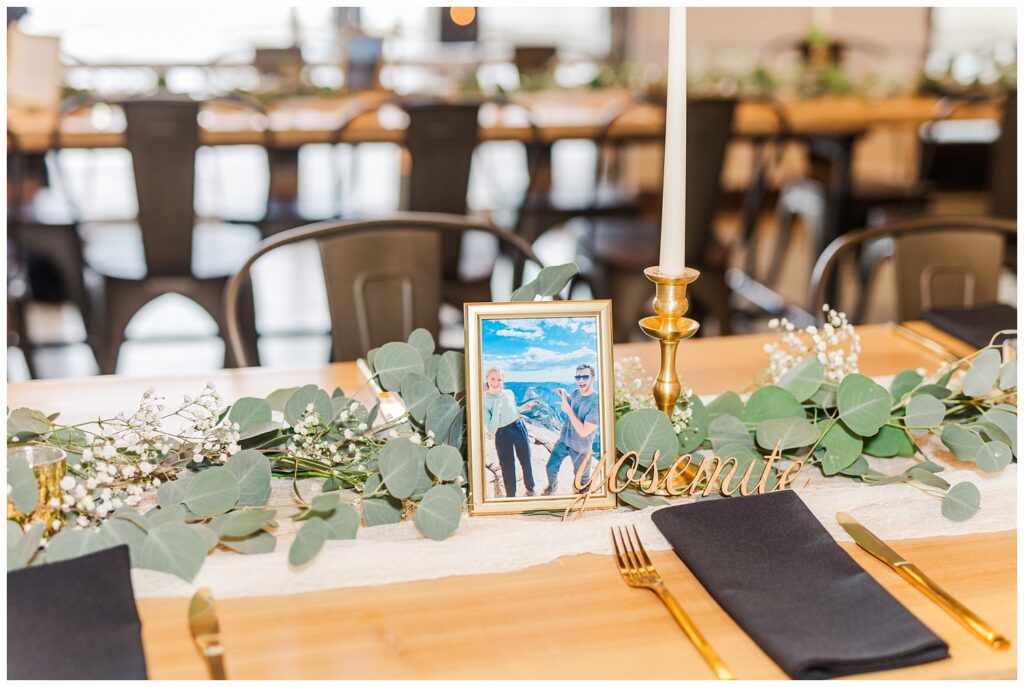 table centerpieces with framed pictures of the bride and groom and garlands