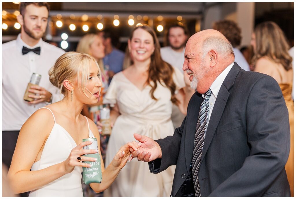 bride dancing with one of her family members at The Meadows Raleigh venue