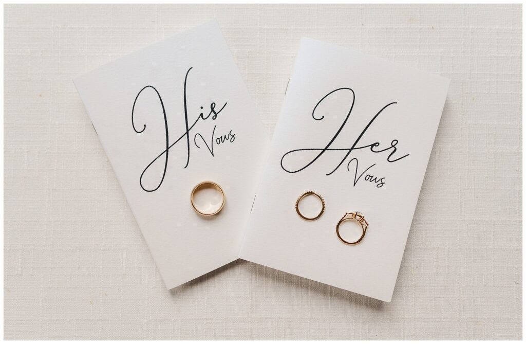 his and hers vow books with wedding rings sitting on top