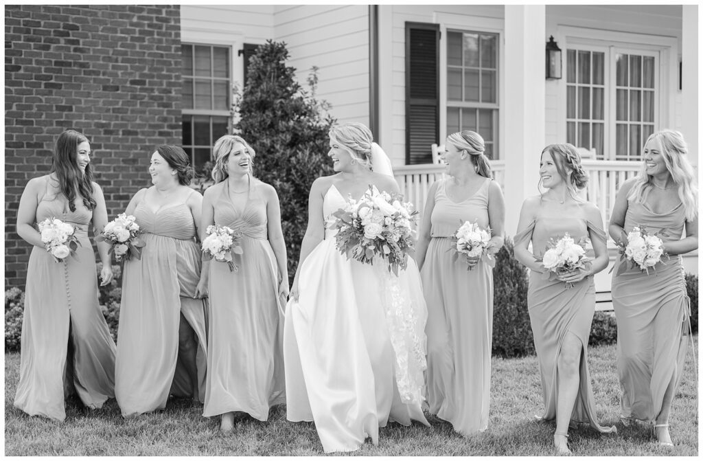 bridal party walking and laughing holding their bouquets