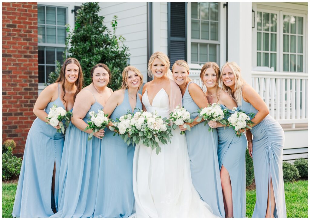 bridal party wearing blue and white and holding white and green bouquets