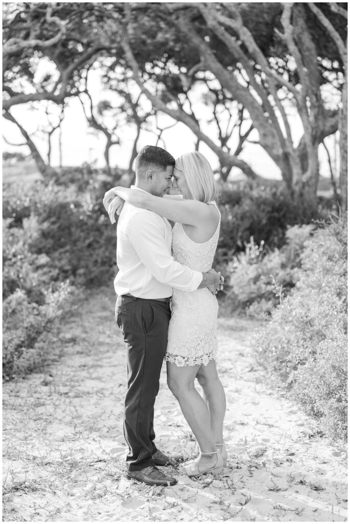 couple holding each other at Fort Fisher beach engagement session