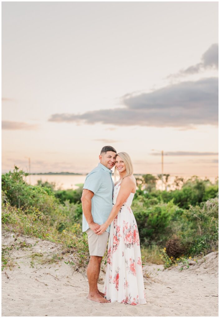 couple holding hands at sunset on the beach at Fort Fisher engagement session