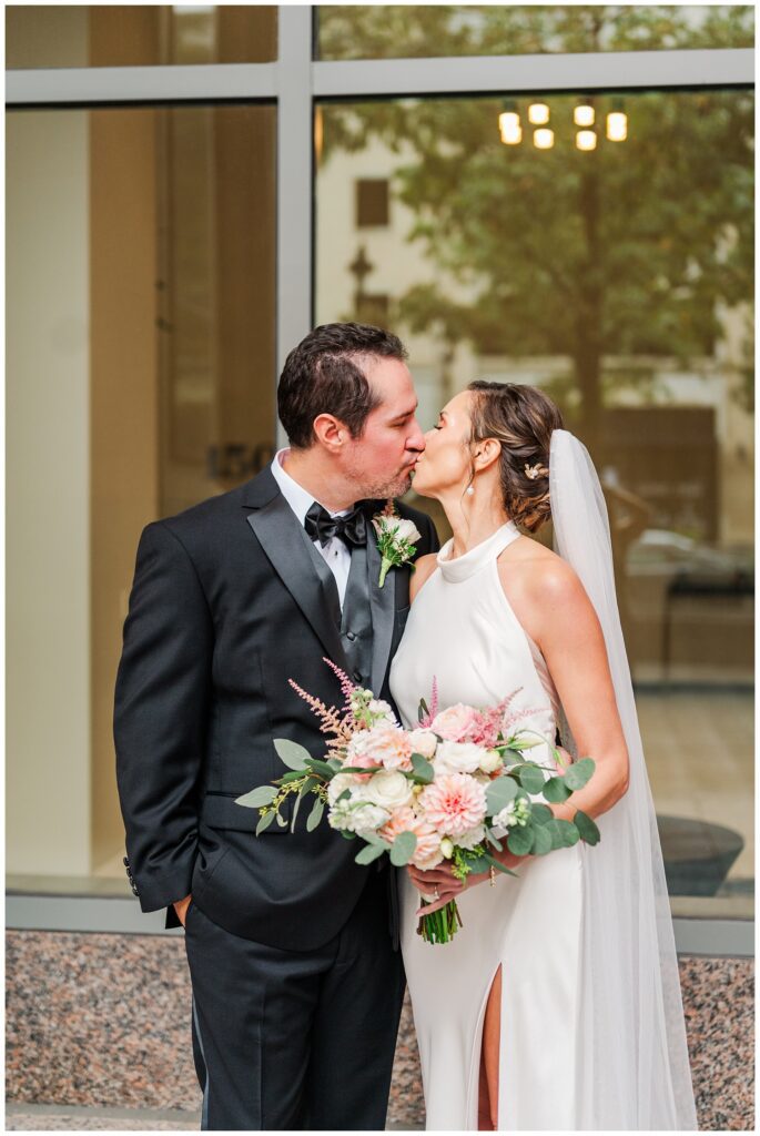 bride and groom share kiss at downtown Raleigh fall wedding