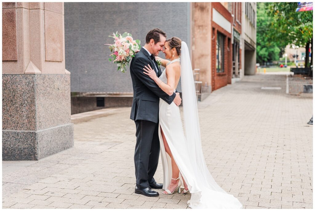groom touching foreheads with bride on the sidewalk at downtown Raleigh wedding venue