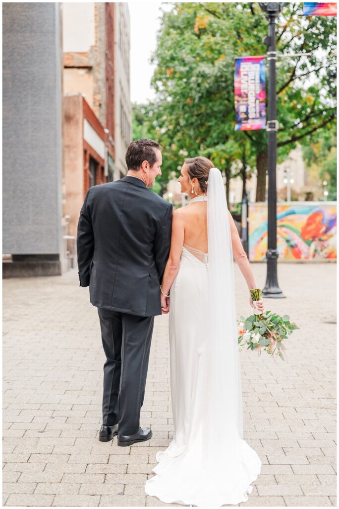 couple walking hand in hand outside for wedding portraits in Raleigh NC