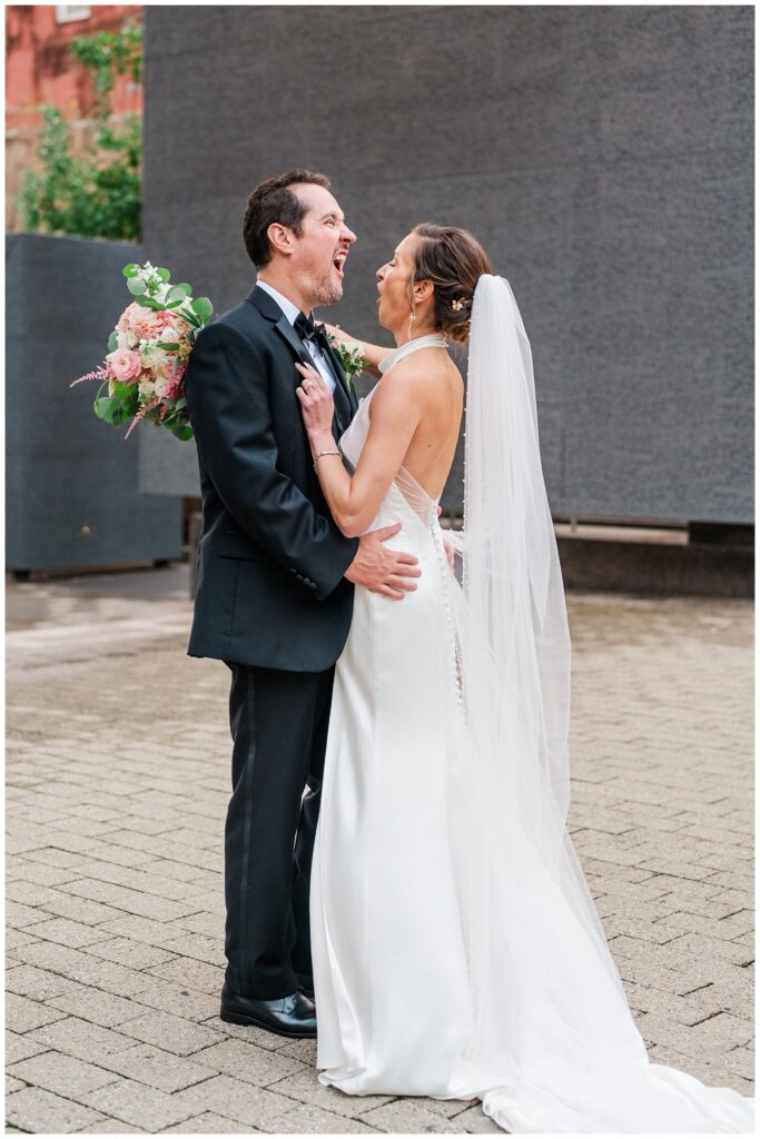 bride and groom making funny faces on the sidewalk in Raleigh NC