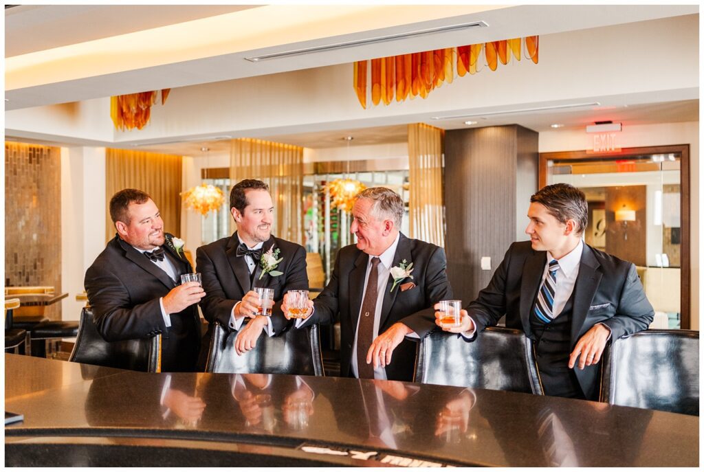 groom and his attendants toasting with some whiskey at the bar at City Club Raleigh