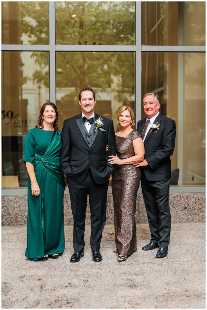 groom posing with his family at Raleigh NC wedding venue