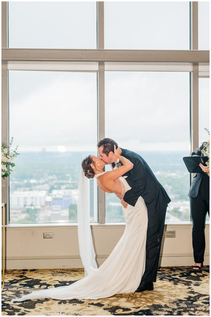 groom dipping back the bride for a kiss after the ceremony at City cCub Raleigh