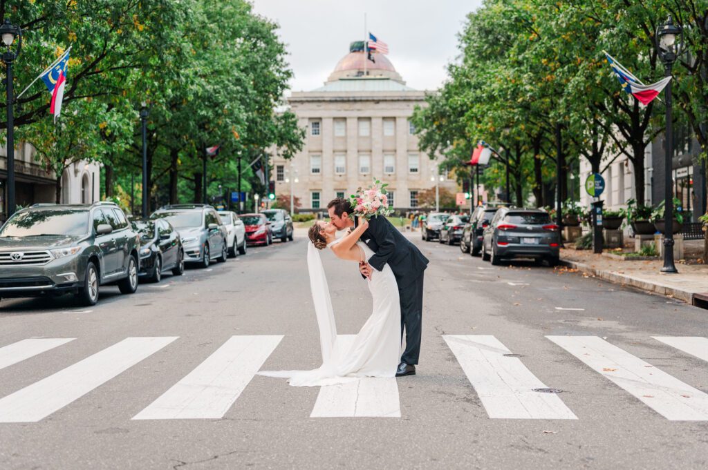 wedding couple dipping back in the middle of crosswalk for a kiss