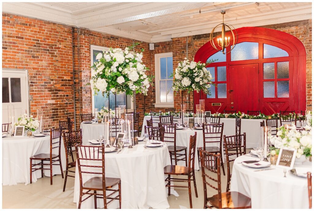 full reception venue with tall and short table centerpieces made by Wilmington wedding florist