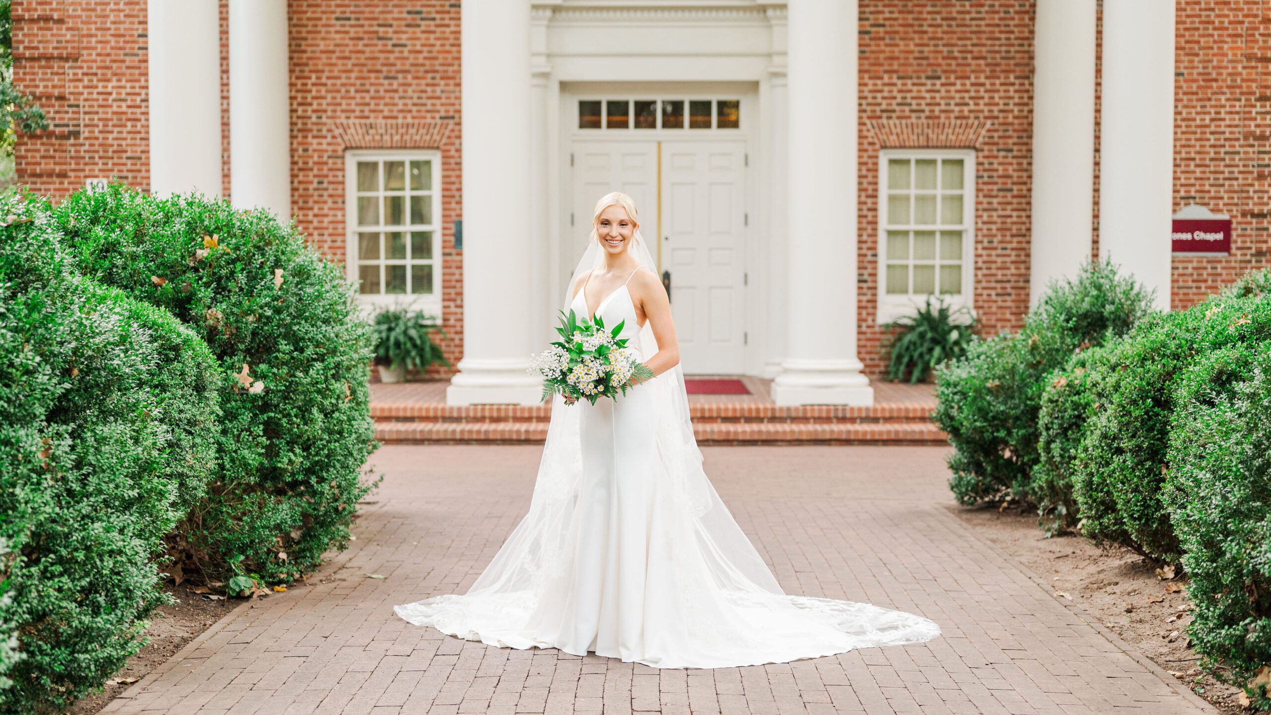 bride holding a bouquet posing at Meredith College in Raleigh