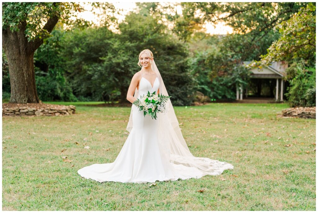 bride posing in the grass during golden hour at Meredith College