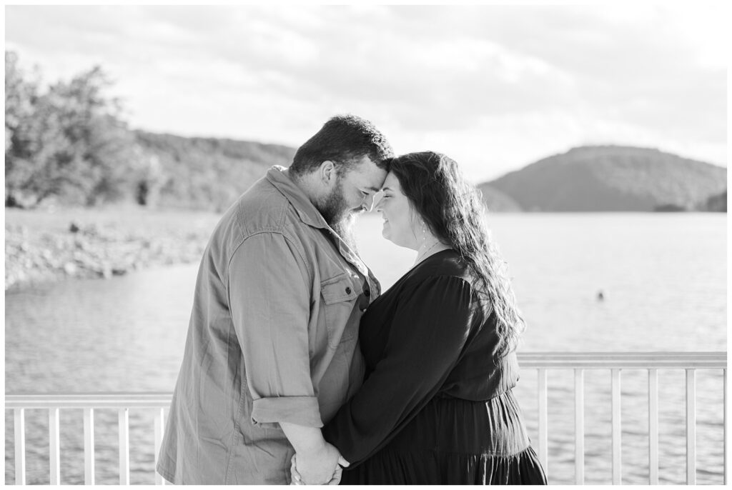 couple touching foreheads next to the lake at Carvins Cove reservoir