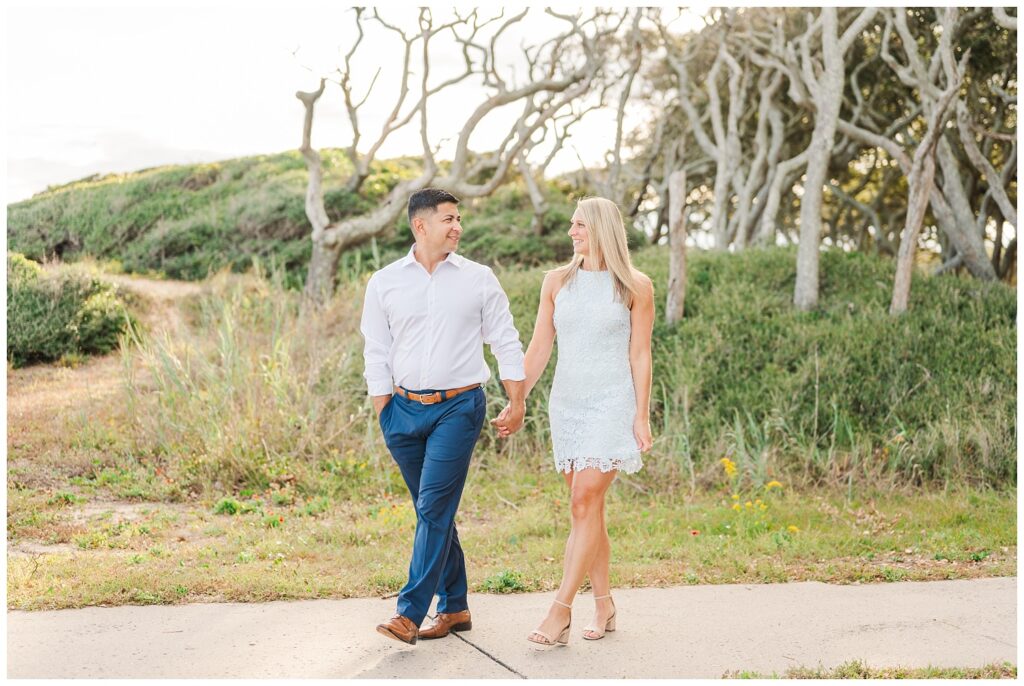 engaged couple walking on the sidewalk at Fort Fisher beach session