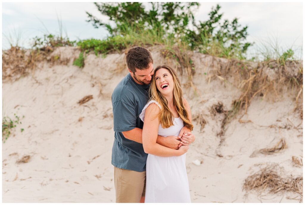 couple laughing near the sand dunes at Wrightsville Beach engagement session