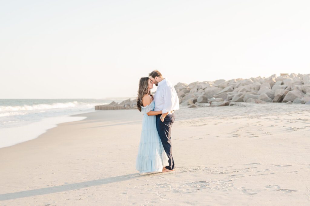 couple standing on the beach at Fort Fisher during golden hour for engagement session