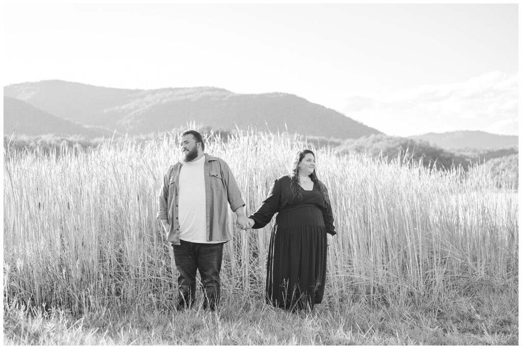 couple standing in a large field for Carvins Cove engagement session