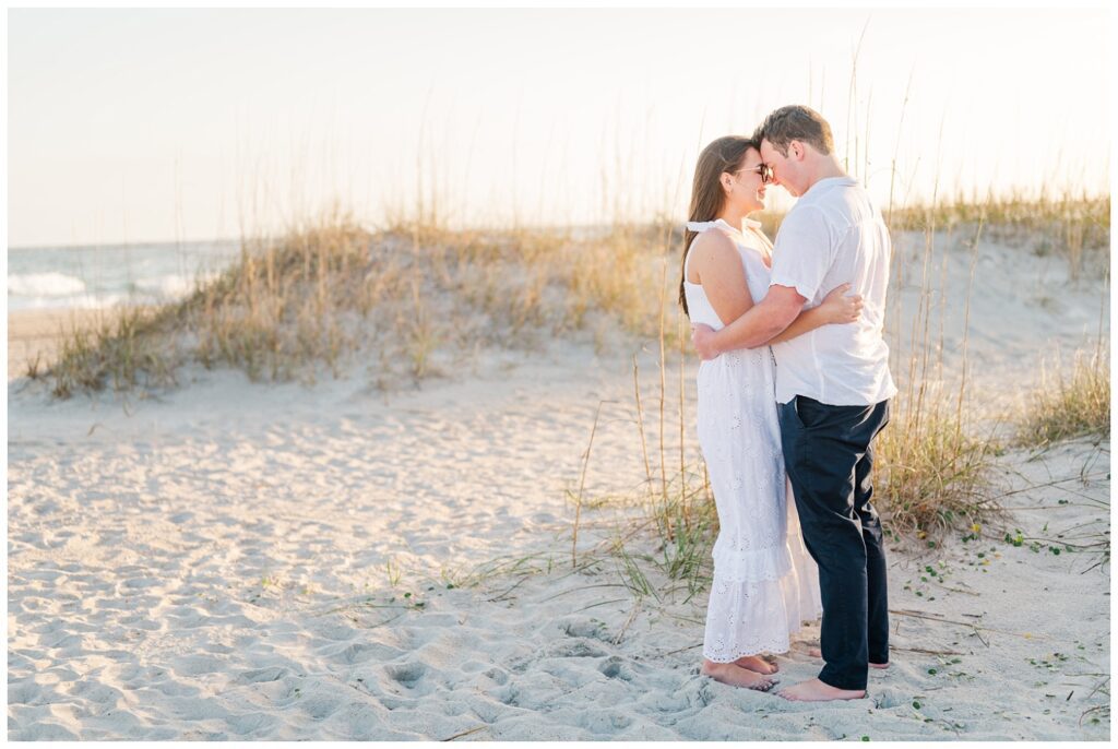 couple holding each other on the sand at Wrightsville Beach session