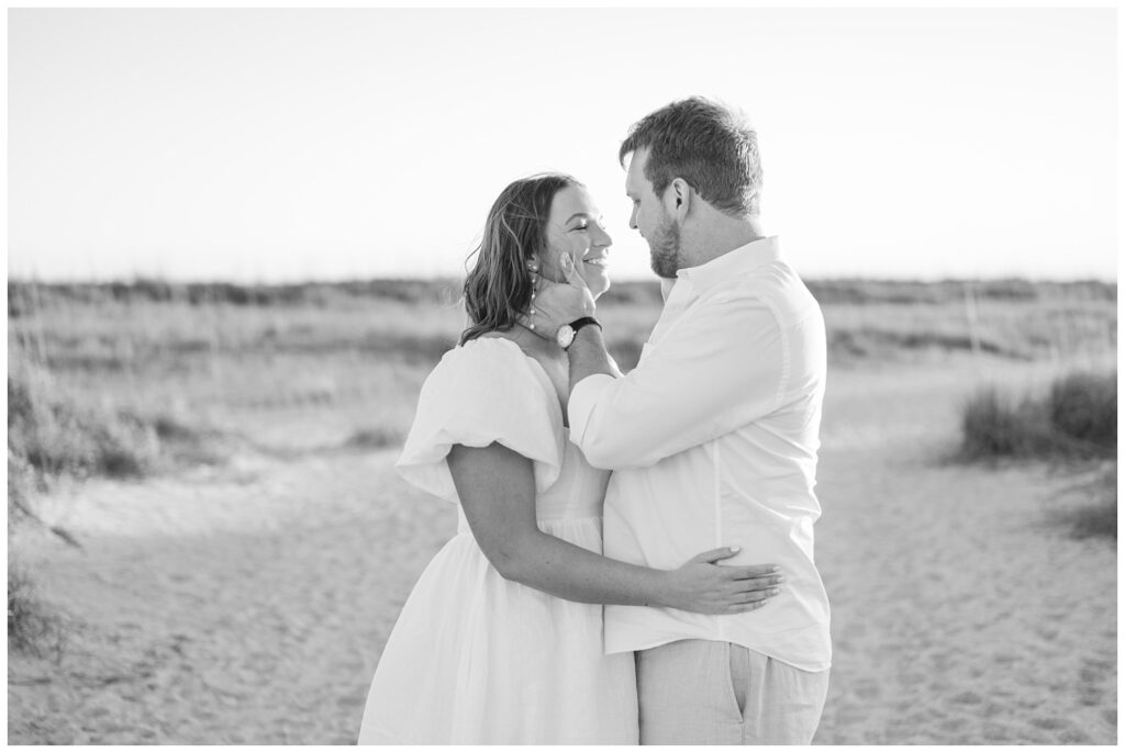 couple smiling at each other during Wrightsville Beach engagement session