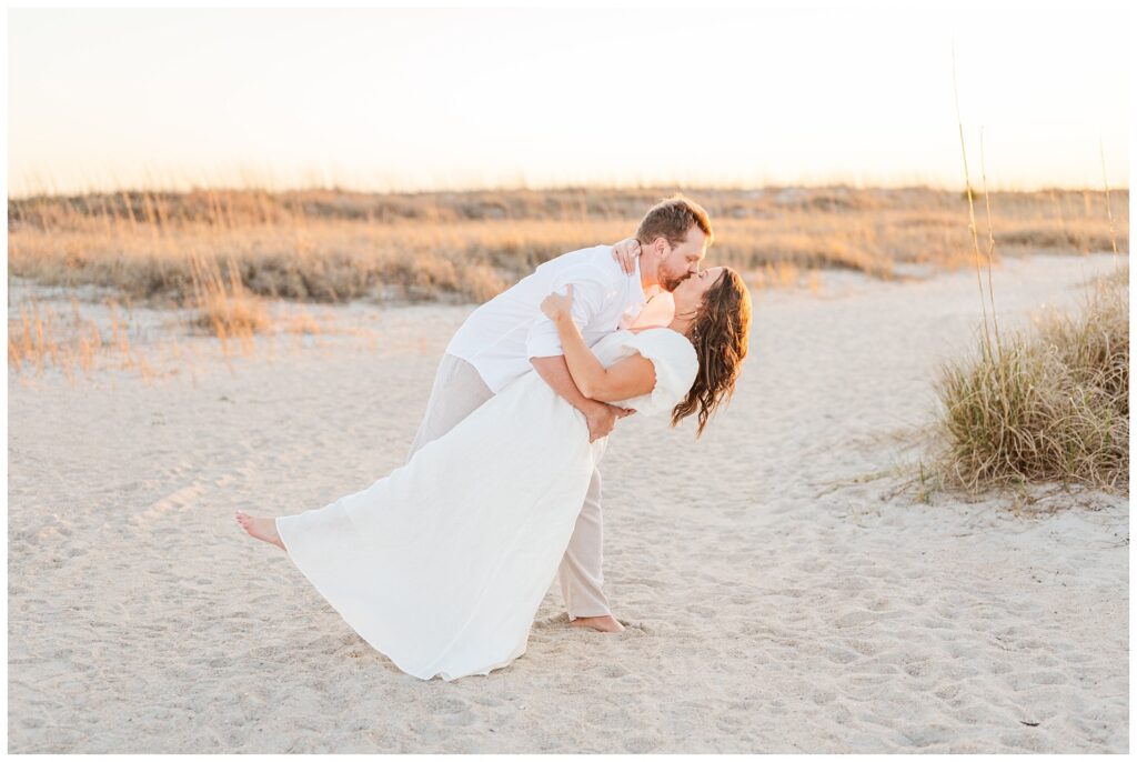 man dipping back his fiance at Wrightsville Beach engagement session