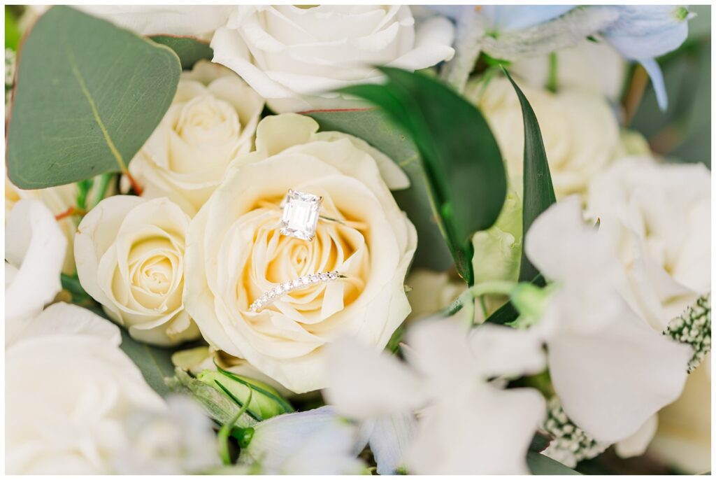 bride's rings sitting inside a white rose in the bouquet 