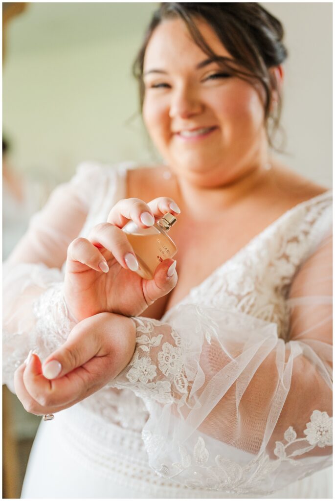 bride spraying her perfume after getting dressed for wedding in Virginia