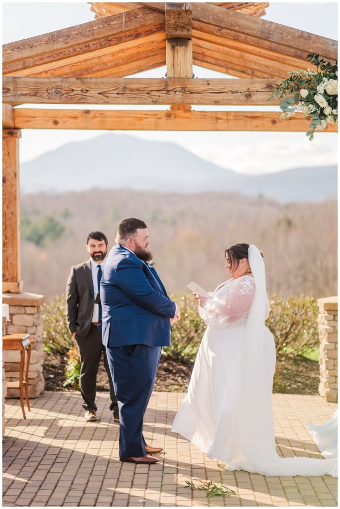 bride reading her own vows to the groom during outdoor ceremony 