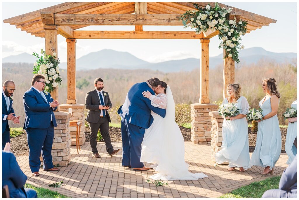 wedding couple share a kiss at the end of the ceremony at Glass Hill Venue