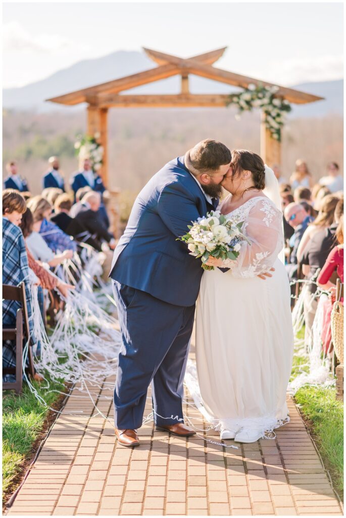 bride and groom share kiss at the end of the aisle after ceremony in Virginia