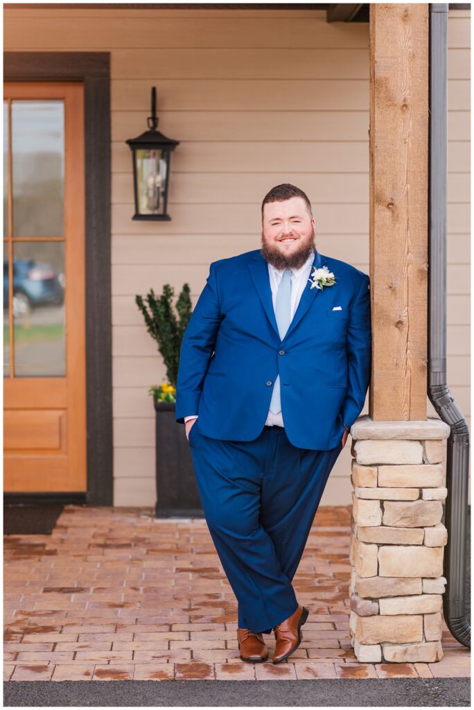 groom posing outside the front of the wedding venue 