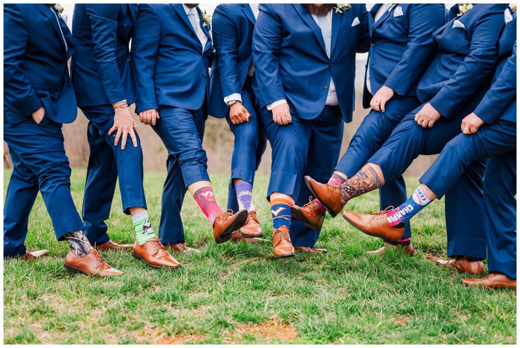 groomsmen showing off their socks at Glass Hill Venue